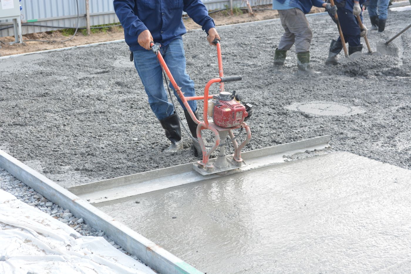 A fresh concrete slab being leveled and finished